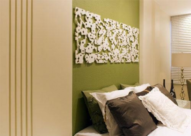 No quarto de Sandra Sahadi, a arquiteta Silvana Andrade aplicou textura em fibra de vidro branca sobre a parede verde na cabeceira da cama, e agradou